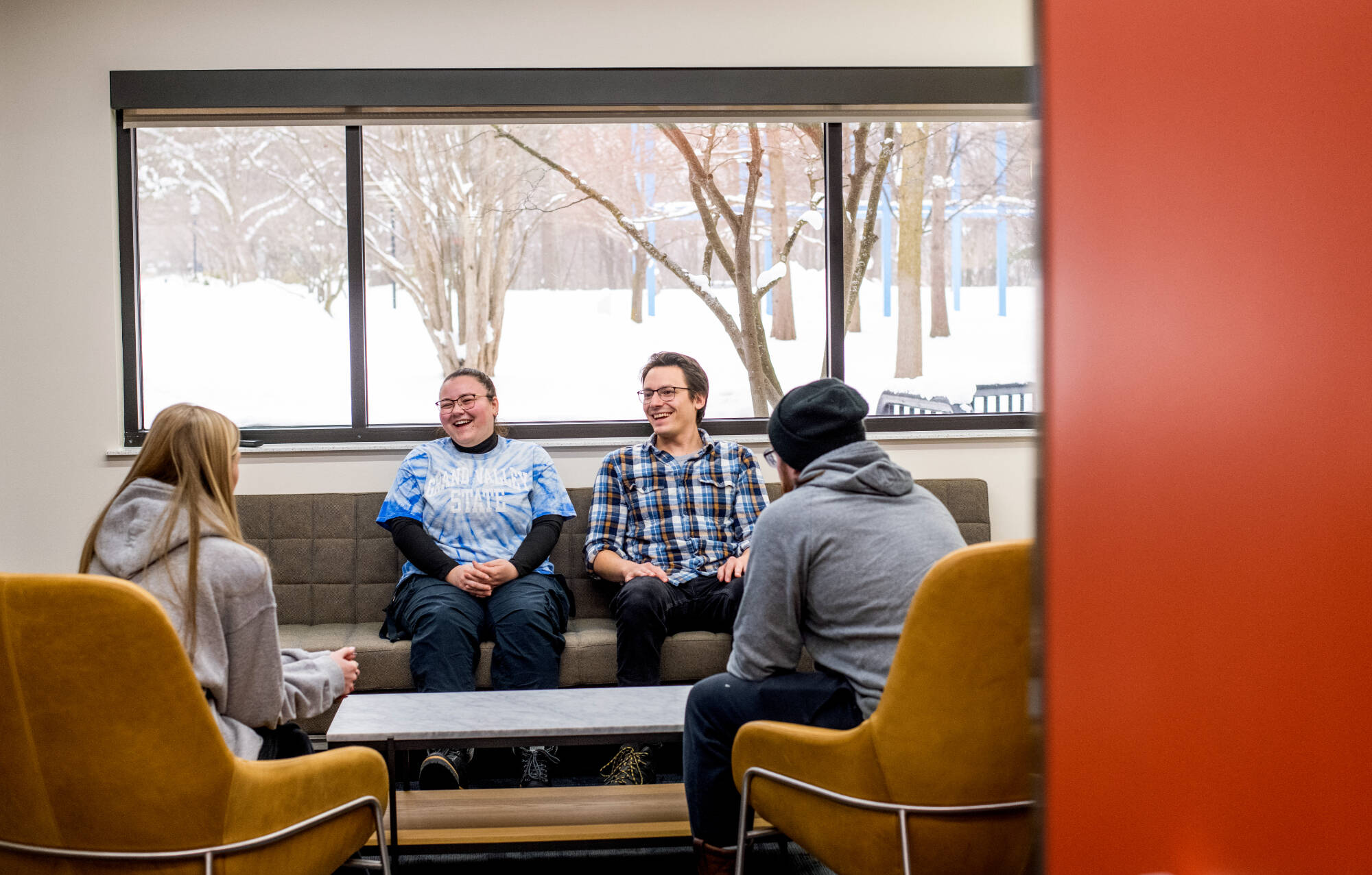 Four research assistants seated on a couch talking